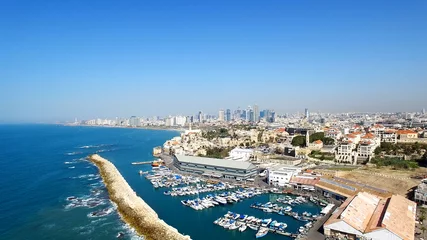 Fotobehang Tel Aviv's modern skyline with Jaffa's ancient port and old city - Aerial image © STOCKSTUDIO