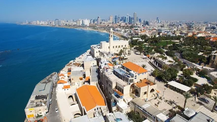 Fotobehang Tel Aviv's modern skyline with Jaffa's ancient port and old city - Aerial image © STOCKSTUDIO