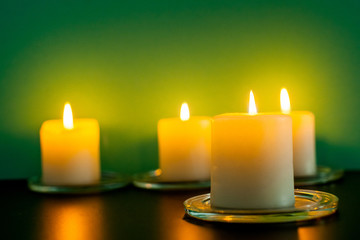 Colorful scented candles on a dark green background