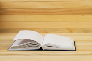 Open book, stack of hardback book on wooden table. Back to school. Copy space. Top view