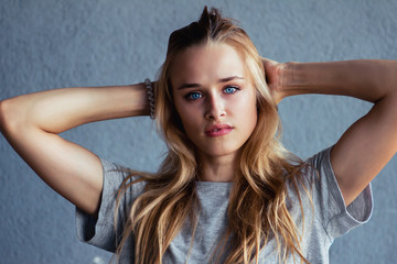 Fototapeta premium Pretty girl with beautiful blue eyes posing on a blue background.