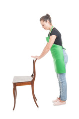 Side view of young employee holding wooden chair