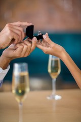 Man proposing to woman offering engagement ring