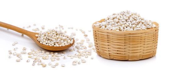 Barley Grains in the basket and wood spoon on white background