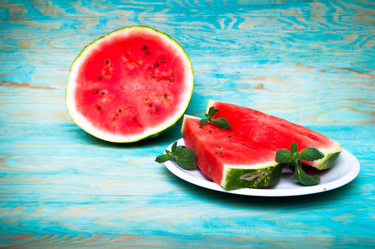 Pieces of watermelon on blue wooden background