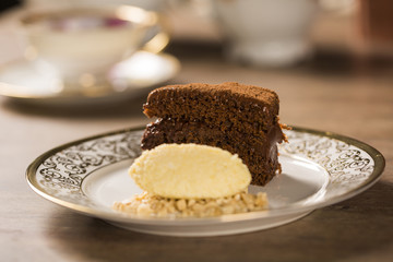 A slice of rich chocolate cake with ice cream and coffee