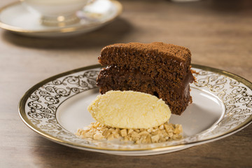 A slice of rich chocolate cake with ice cream and coffee