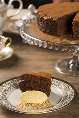 A slice of rich chocolate cake with ice cream and coffee