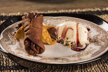 Cannoli with ice cream, chocolate and almonds