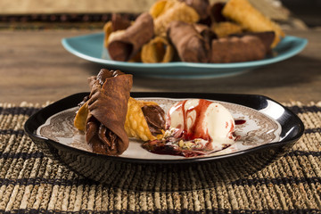 Cannoli with ice cream, chocolate and almonds