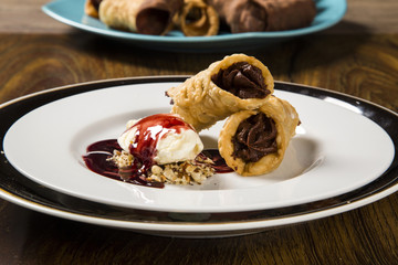 Cannoli with ice cream, chocolate and almonds