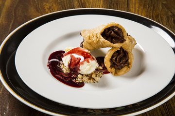 Cannoli with ice cream, chocolate and almonds