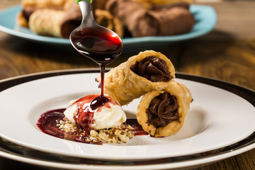Cannoli with ice cream, chocolate and almonds
