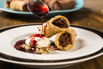 Cannoli with ice cream, chocolate and almonds