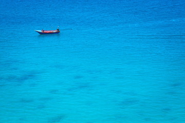 The boat in the azure ocean