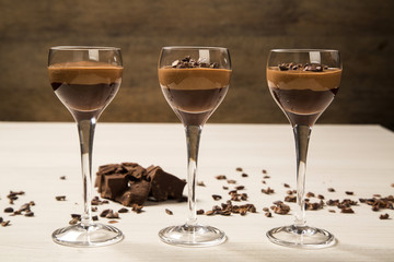 Chocolate mousse in a glasses on a wooden background