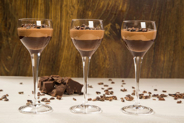 Chocolate mousse in a glasses on a wooden background