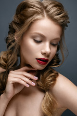 Naklejka premium Beautiful girl with braids and gentle makeup. Nude. Beauty model with bright red lips. Beautiful face. The photo was taken in studio 