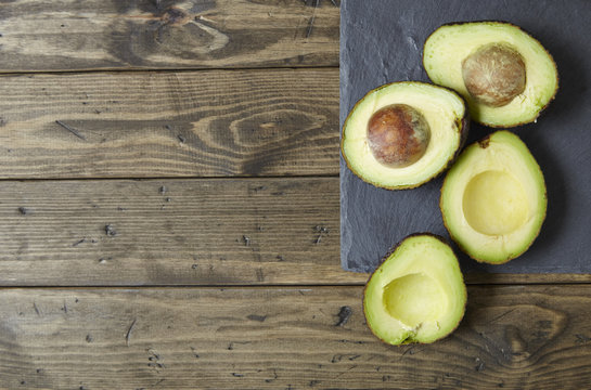 Halved avocados on a distressed wooden counter top background