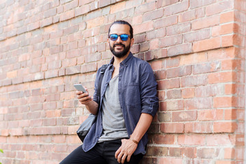 Obraz premium man with backpack texting on smartphone in city