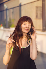 Beautiful woman talking on smartphone in the city, in front of modern building.