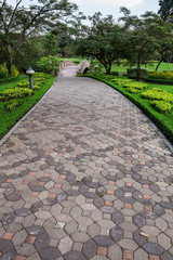 Obraz premium The Stone block walk path in the park with green grass backgroun