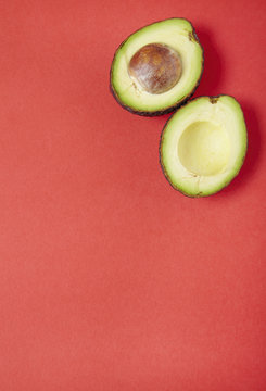 A halved avocado arranged on a red background forming a page border