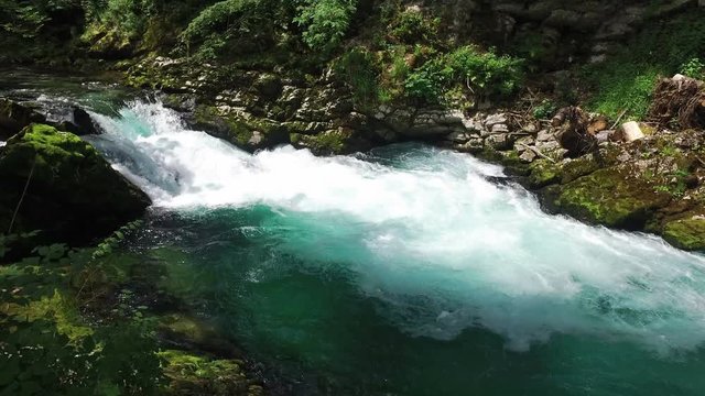 4K. Wild Radovna river flows in Vintgar Gorge. Clean blue water and green forest. Triglav National Park, Julian Alps, Bled valley, Slovenia, Europe.