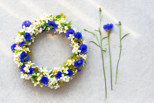 Bluet floral wreath on concrete background.
