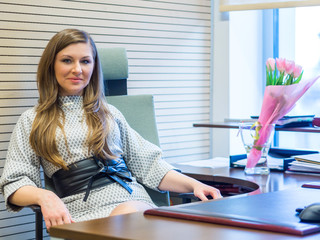 Beautiful Russian girl sits in an office chair boss