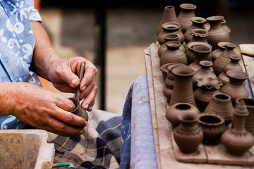 Workers producing handmade art vase earthenware at market.