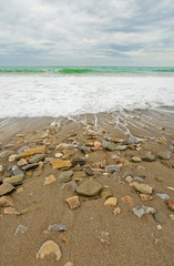sea beach with rocks in stormy weather