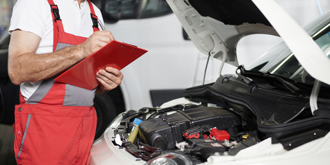 Car mechanic checks a car in a garage