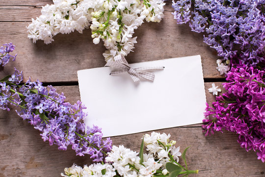 Aromatic lilac flowers  and empty tag on vintage wooden table.