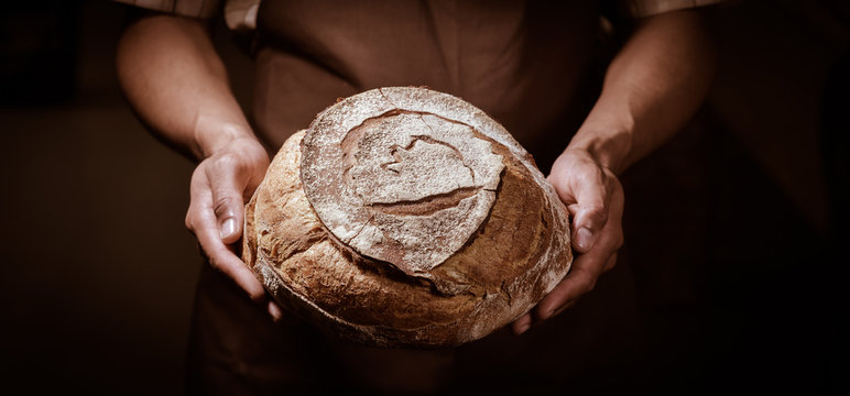 Baker man holding a round bread