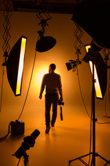 Silhouette of photographer and studio shot as workplace - obrazy, fototapety, plakaty