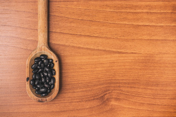 Black beans into a spoon. Phaseolus vulgaris 'Black turtle
