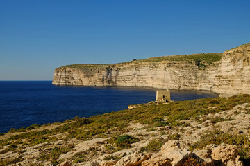 Fototapeta na wymiar The Watchtower on the sandstone cliffs at Xlendi bay on the Island of Gozo, Malta. 