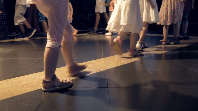 Children are walking in a huge circle on the dance floor. Families are having a great time. Kids are able to find a fun activity in any sport.