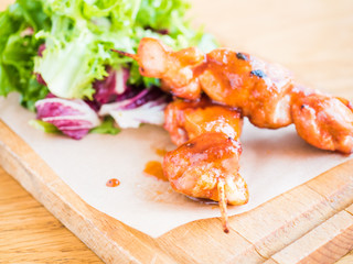 chicken with sauce on a skewer and vegetable