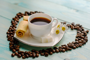 Coffee cup with wafer and biscuit on blue wood background