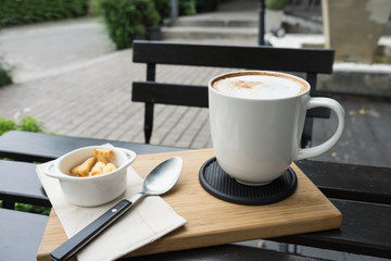hot fresh coffee in white cup on black table on wooden tray biscuit cookie and silver spoon and white saucer cappuccino coffee mocha coffee espresso coffee latte coffee / hot fresh coffee cookie