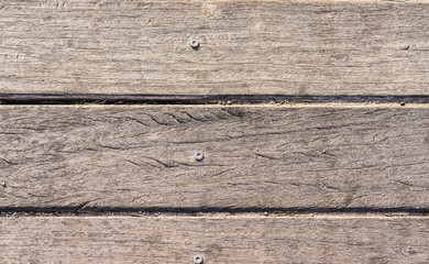 wooden slats with screw horizontally on the beach worn by the sun background