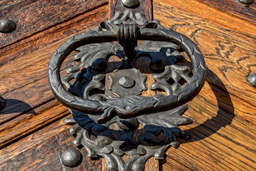 Old metal handle knocker on a wooden door