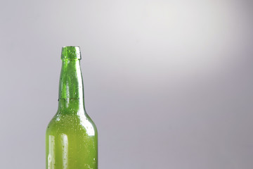 One bottle of apple cider, over a grey background.