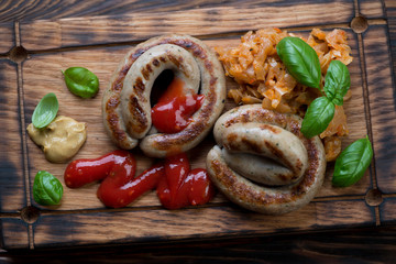 Close-up of grilled coiled sausages with braised cabbage