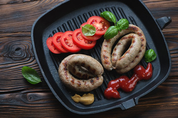 Cast-iron grill pan with roasted coiled sausages