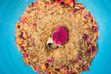 A dried rosebud garnishes a bowl of advieh, a Middle Eastern spice mix of cumin, cardomom, cinnamon, golpar, and rose petals.