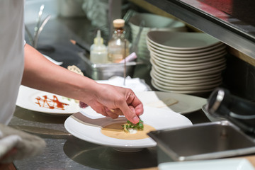 Obraz na płótnie Canvas chef dressed in white uniform decorating food 
