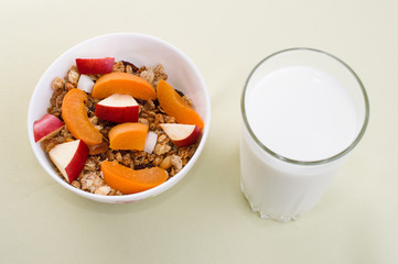 muesli with peach, apple and a glass of milk
